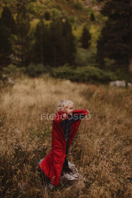 Young boy standing on rock, wrapped in sleeping bag, Mineral King, Sequoia National Park, California, USA — Stock Photo
