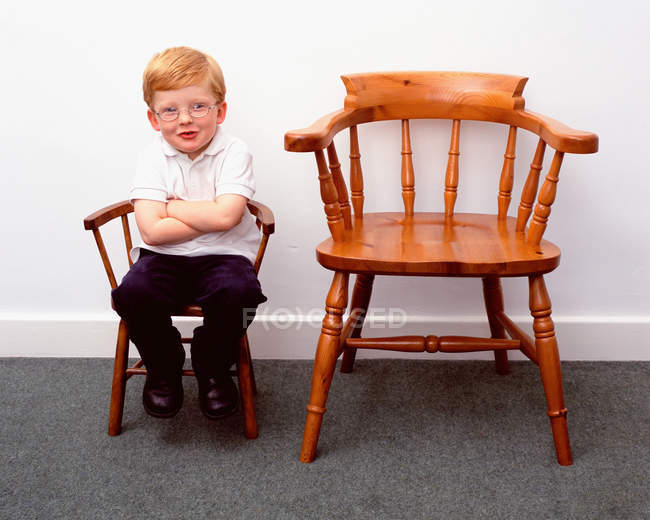 Menino e pequenas e grandes cadeiras — Fotografia de Stock