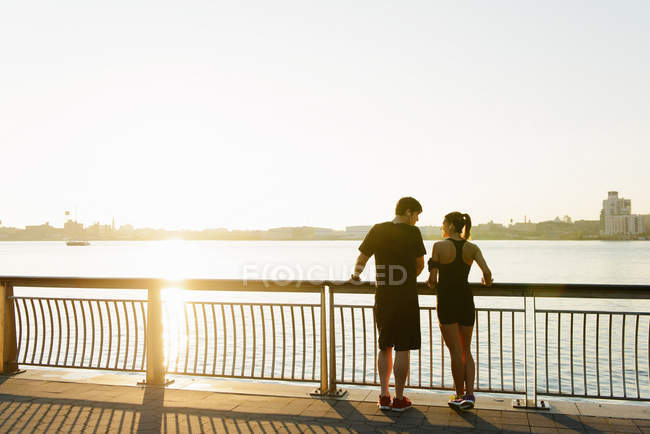Couple jogging debout sur le bord de la rivière — Photo de stock