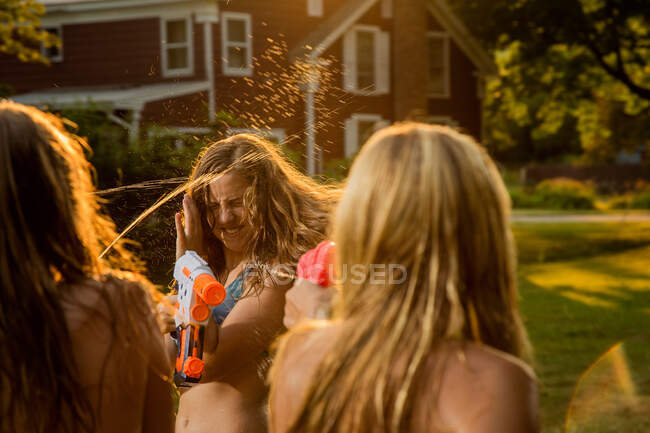 Девушки дерутся на воде с водяными пистолетами — стоковое фото