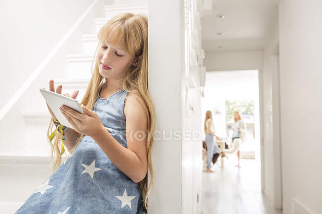 Девушка в коридоре с цифровым планшетом — стоковое фото
