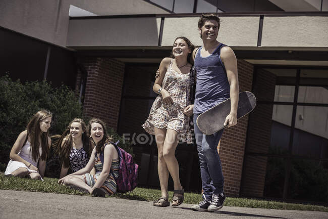 Adolescentes pareja de secundaria dejando la escuela secundaria juntos - foto de stock