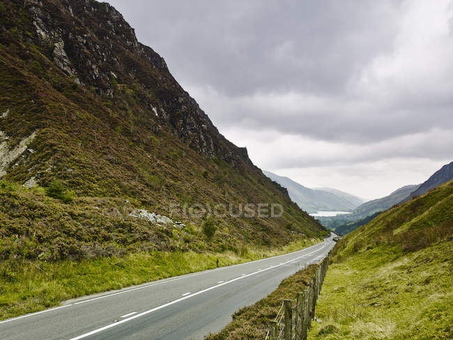 Route rurale et collines couvertes de verdure luxuriante — Photo de stock