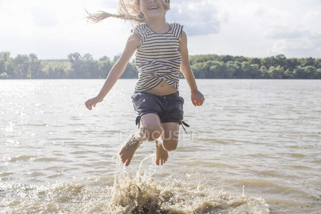 Mädchen springt und planscht in Fluss — Stockfoto