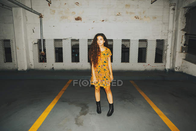 Portrait of young woman looking sideways standing in indoor parking lot — Stock Photo