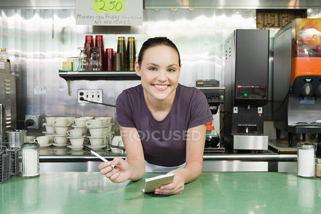 Camarera sonriente en un restaurante - foto de stock