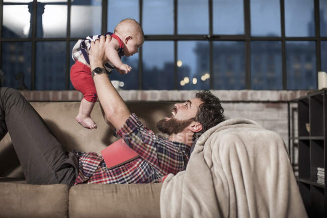 Pai brincando com bebê em casa — Fotografia de Stock