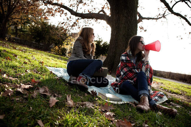Chicas animando a amigos en el parque - foto de stock