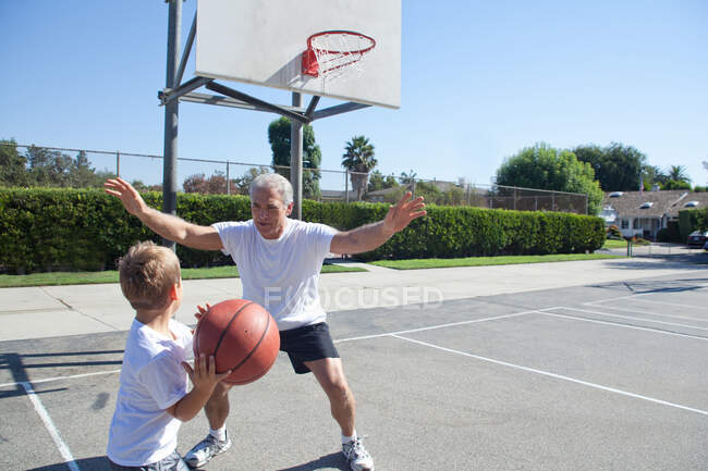 Хлопчик і дідусь грають у баскетбол — стокове фото