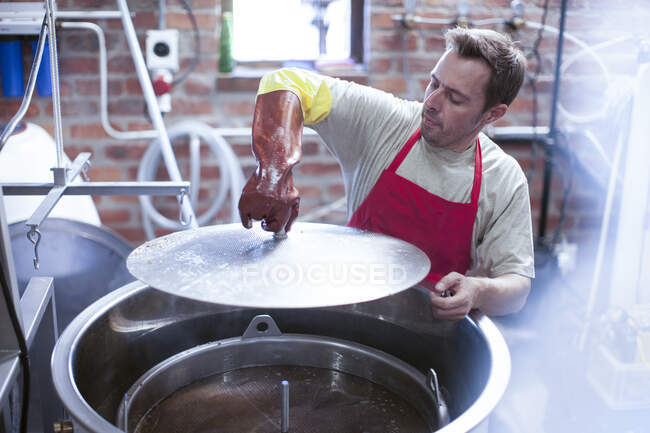 Cape Town, South Africa, male pouring down in open container in brewery room — Stock Photo