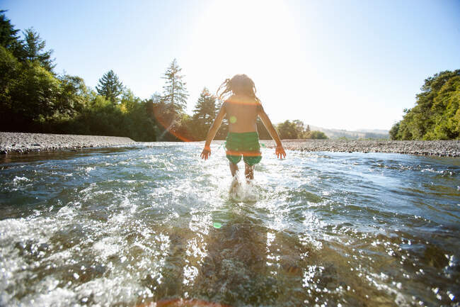 Girl jumping in river — Stock Photo