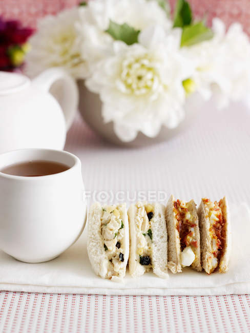 Sanduíches fatiadas com xícara de chá — Fotografia de Stock