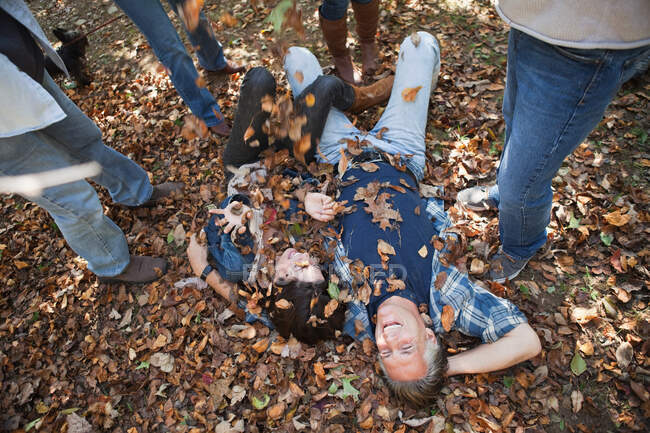 Friends throwing autumn leaves on couple — Stock Photo