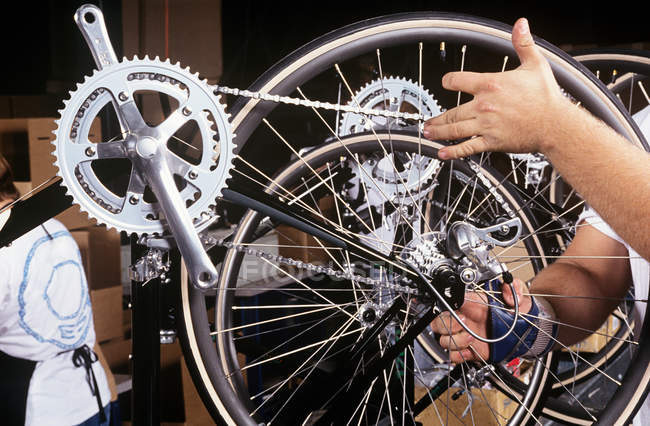 Trabajador de fábrica comprobar una rueda de bicicleta - foto de stock