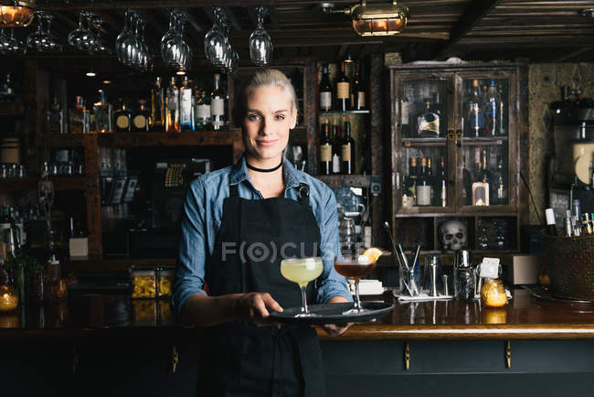 Офіціантка тримає лоток коктейлів у кафе — стокове фото