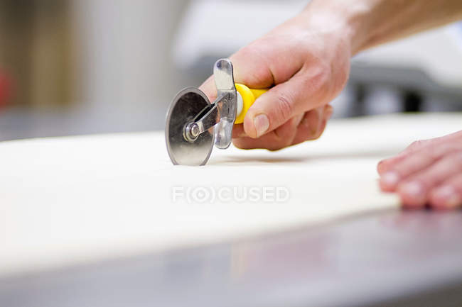 Cropped image of Baker cutting dough in kitchen — Stock Photo