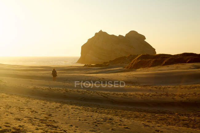 Mujer caminando por la playa, Nueva Zelanda - foto de stock