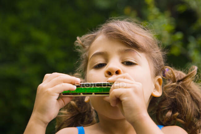 A girl playing the harmonica — Stock Photo