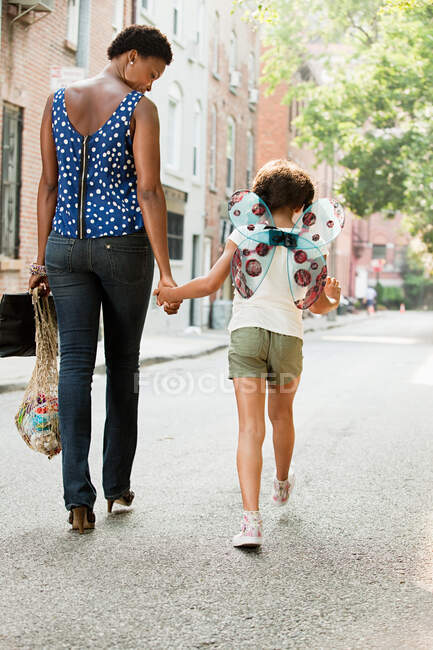 Mutter und Tochter gehen die Straße entlang, Rückansicht — Stockfoto