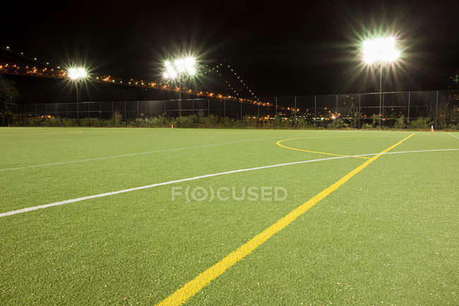Terrain de football vide éclairé par des lumières la nuit — Photo de stock