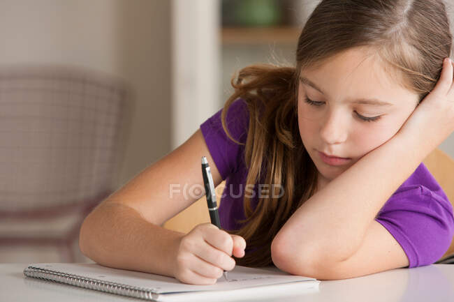 Chica escribiendo en cuaderno - foto de stock