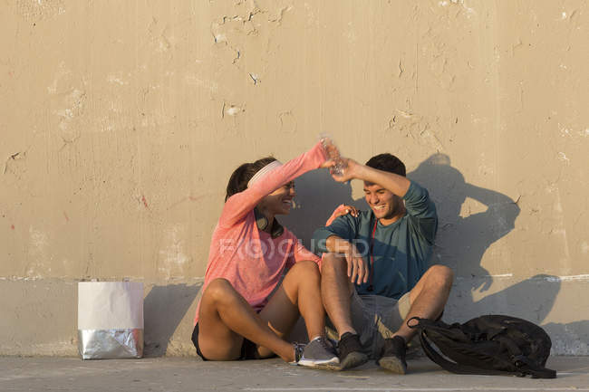 Casal brincando na frente da parede de concreto — Fotografia de Stock