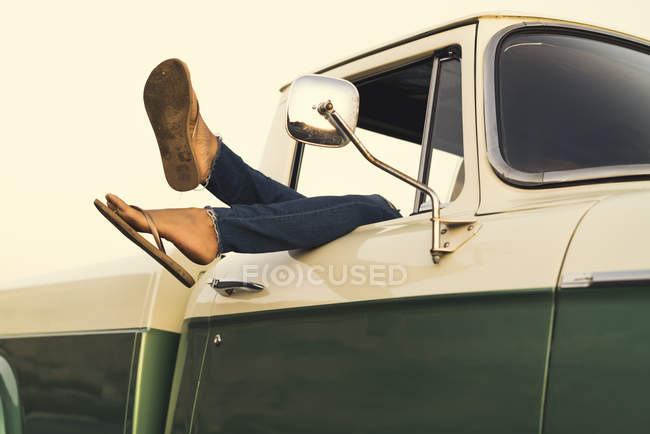 Legs of young woman out of pickup truck window at Newport Beach, California, USA — Stock Photo