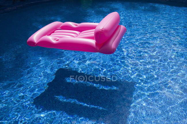 Letto ad aria gonfiabile rosa galleggiante in piscina in estate, Quebec, Canada — Foto stock