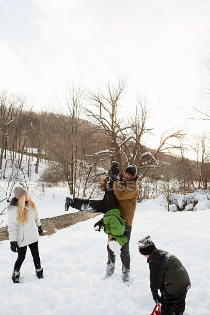 Семья играет в снегу вместе — стоковое фото