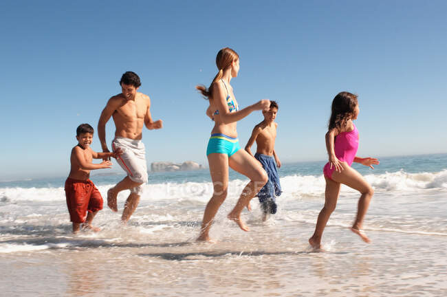 Famiglia che gioca su una spiaggia — Foto stock