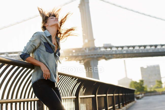 Jeune femme aux cheveux balayés par le vent, Manhattan Bridge, Brooklyn, USA — Photo de stock
