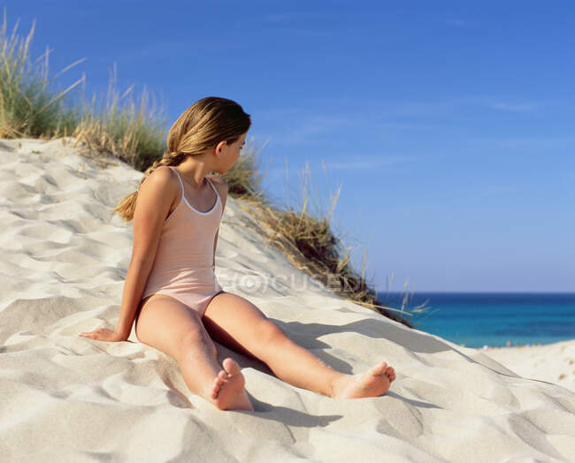 Ragazza seduta su una duna di sabbia — Foto stock