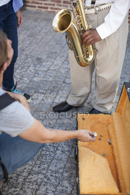 Ciudad del Cabo, Sudáfrica, hombre en la multitud repartiendo dinero para tocar el saxofón - foto de stock