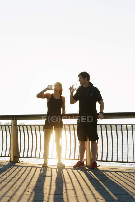 Jogging coppia bere acqua mattina presto — Foto stock