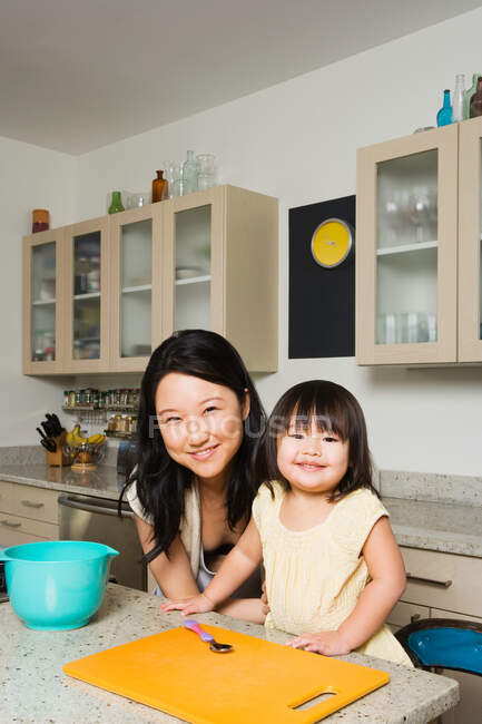 Дочь, помогающая матери на кухне — стоковое фото