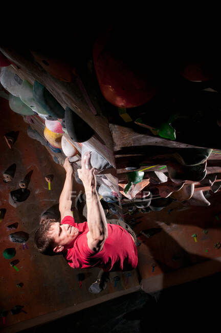 Man climbing indoor rock wall — Stock Photo