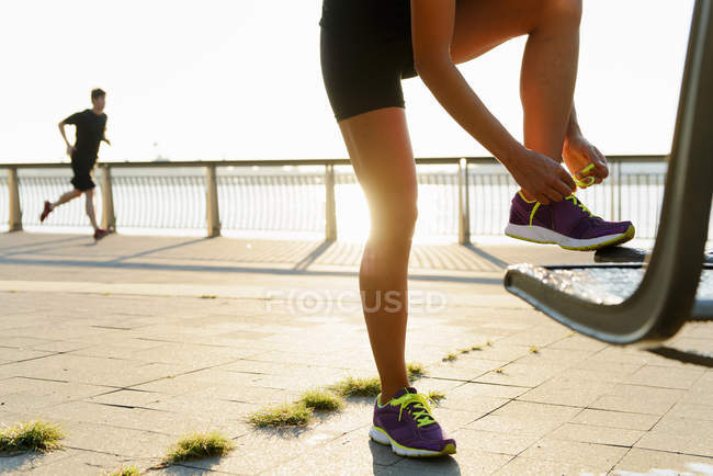 Giovane femmina jogger lacci di fissaggio — Foto stock