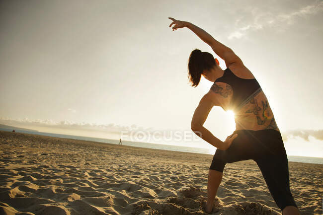 Frau macht Stretching-Übung am Strand — Stockfoto