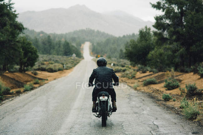 Rear view of motorcyclist riding motorbike on open road, Kennedy Meadows, California, USA — Stock Photo