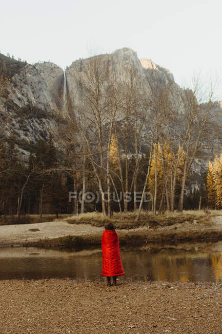 Rückansicht einer in eine rote Decke gehüllten Frau mit Blick auf den Berg, Yosemite-Nationalpark, Kalifornien, USA — Stockfoto