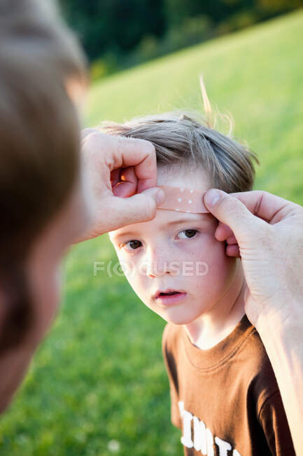 Pai Aplicando bandagem à cabeça do filho — Fotografia de Stock