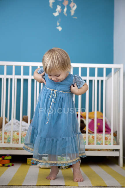 Weibliches Kleinkind bewundert ihr Partykleid im Schlafzimmer — Stockfoto