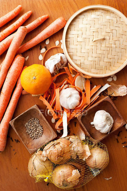 Aglio cipolle arancioni e carote sul tavolo — Foto stock