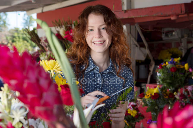 Retrato de floristería sonriente trabajando en la tienda - foto de stock