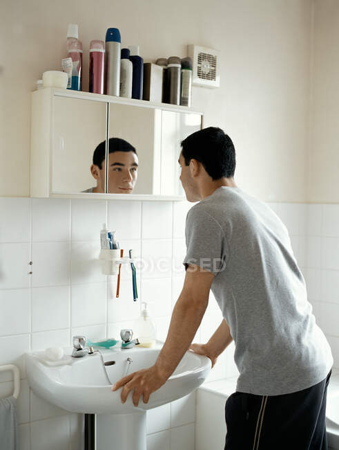 Adolescent garçon debout dans salle de bain — Photo de stock