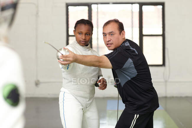 Fencing tutor assisting female student — Stock Photo