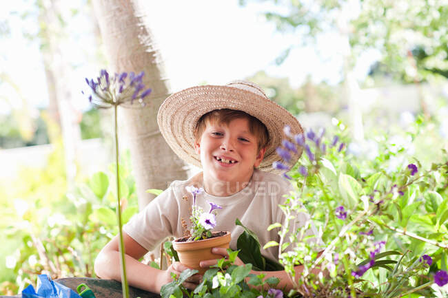 Garoto vasos plantas ao ar livre — Fotografia de Stock