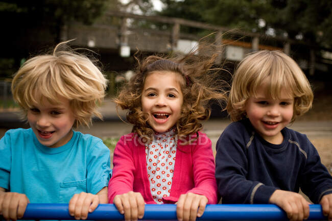 Tres niños en el parque infantil - foto de stock