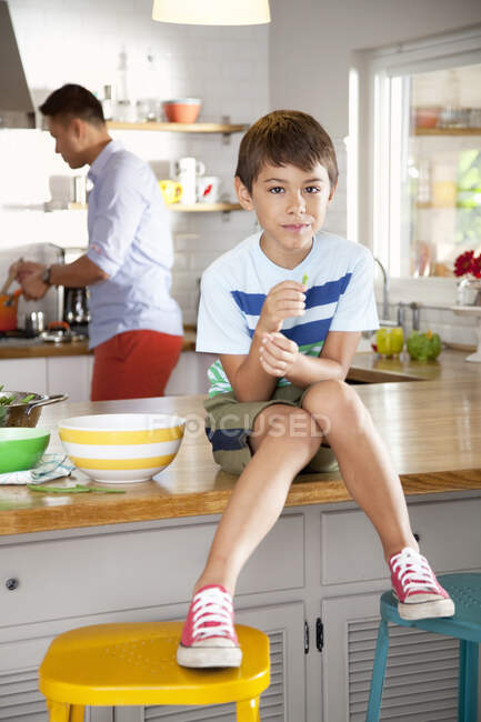 Junge sitzt auf Küchentisch — Stockfoto