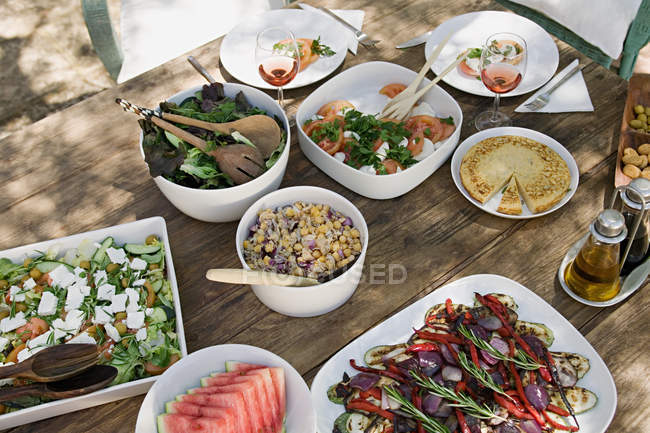 Cibo mediterraneo servito sul tavolo da giardino — Foto stock
